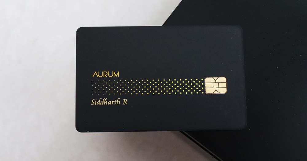 SBI Aurum Credit Card front and back design on a marble background, Luxury welcome kit included with SBI Aurum Credit Card, Business traveler using SBI Aurum Credit Card in an airport lounge, SBI Aurum cardholder enjoying fine dining at a luxury restaurant, Screenshot of SBI Aurum rewards redemption portal, Close-up of SBI Aurum card with contactless payment feature,